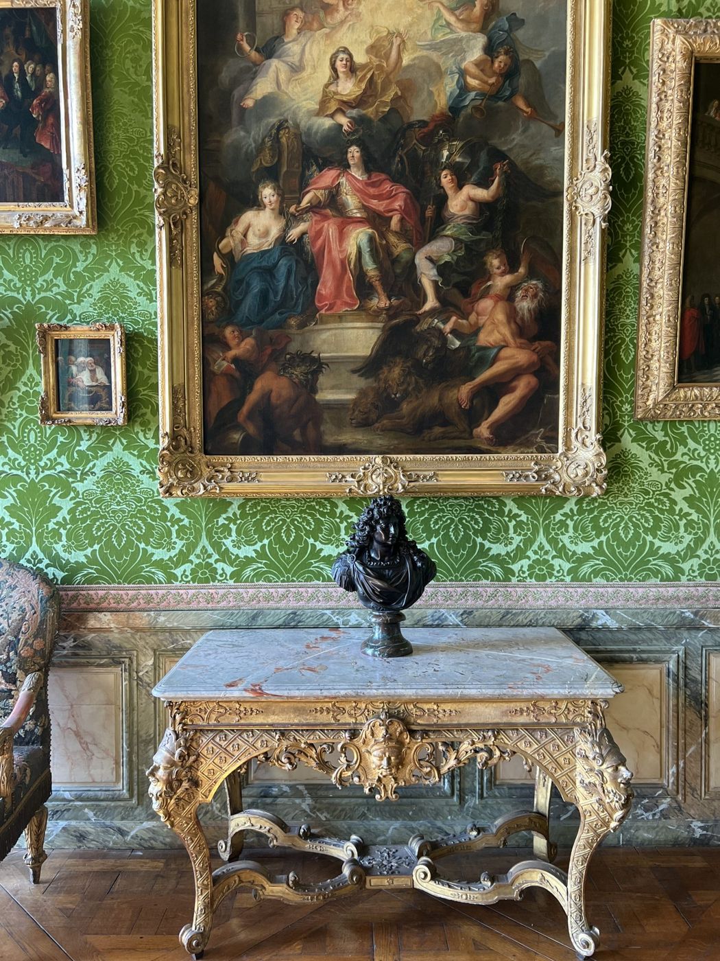 Mur tendu de damas vert, console sculptée et grand tableau