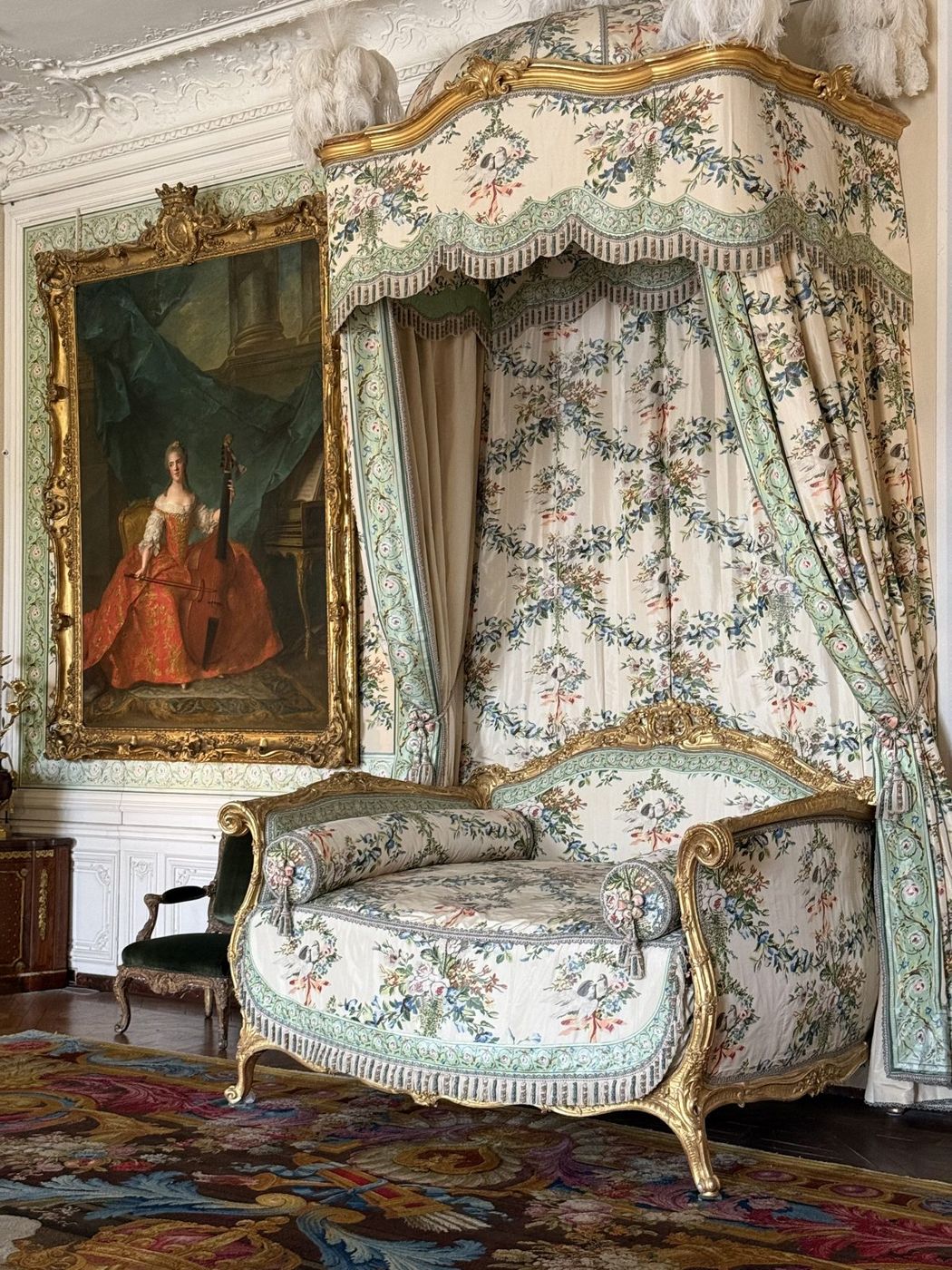 Lit à la polonaise sous une tenture fleurie